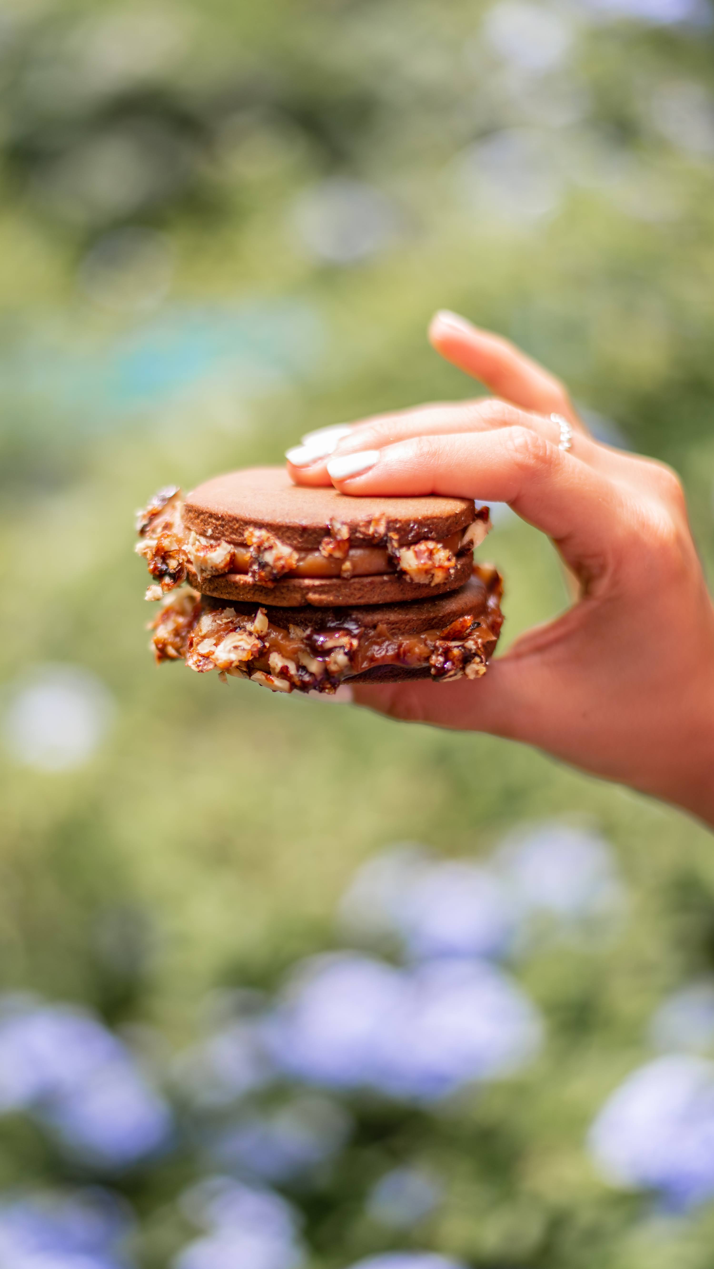 Alfajores de cacao, dulce de leche con centro de ganache de chocolate y nueces caramelizadas